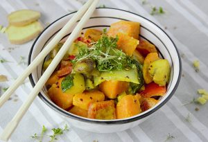 Colorful vegetable stir fry with fresh herbs served in a bowl with chopsticks for a healthy meal.