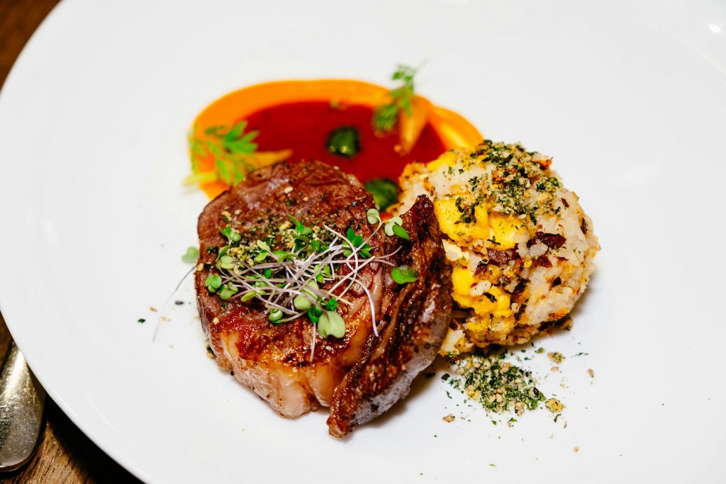 Elegant gourmet dish featuring seared beef and vegetable sides in Calgary.