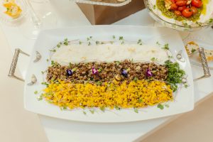 Exquisite platter featuring colorful sliced yellow peppers, rice mix, and fresh herbs.