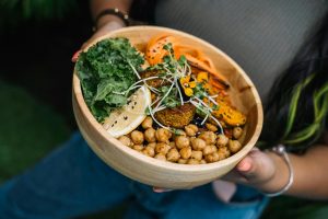 Healthy vegan bowl with chickpeas, kale, carrots, and lemon served fresh.