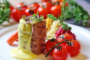 Close-up of a gourmet dish featuring fresh tomatoes and a creamy sauce on a white plate.