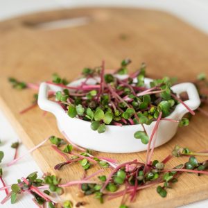 Crisp garden cress sprouts on a wooden board, perfect for health-focused culinary uses.